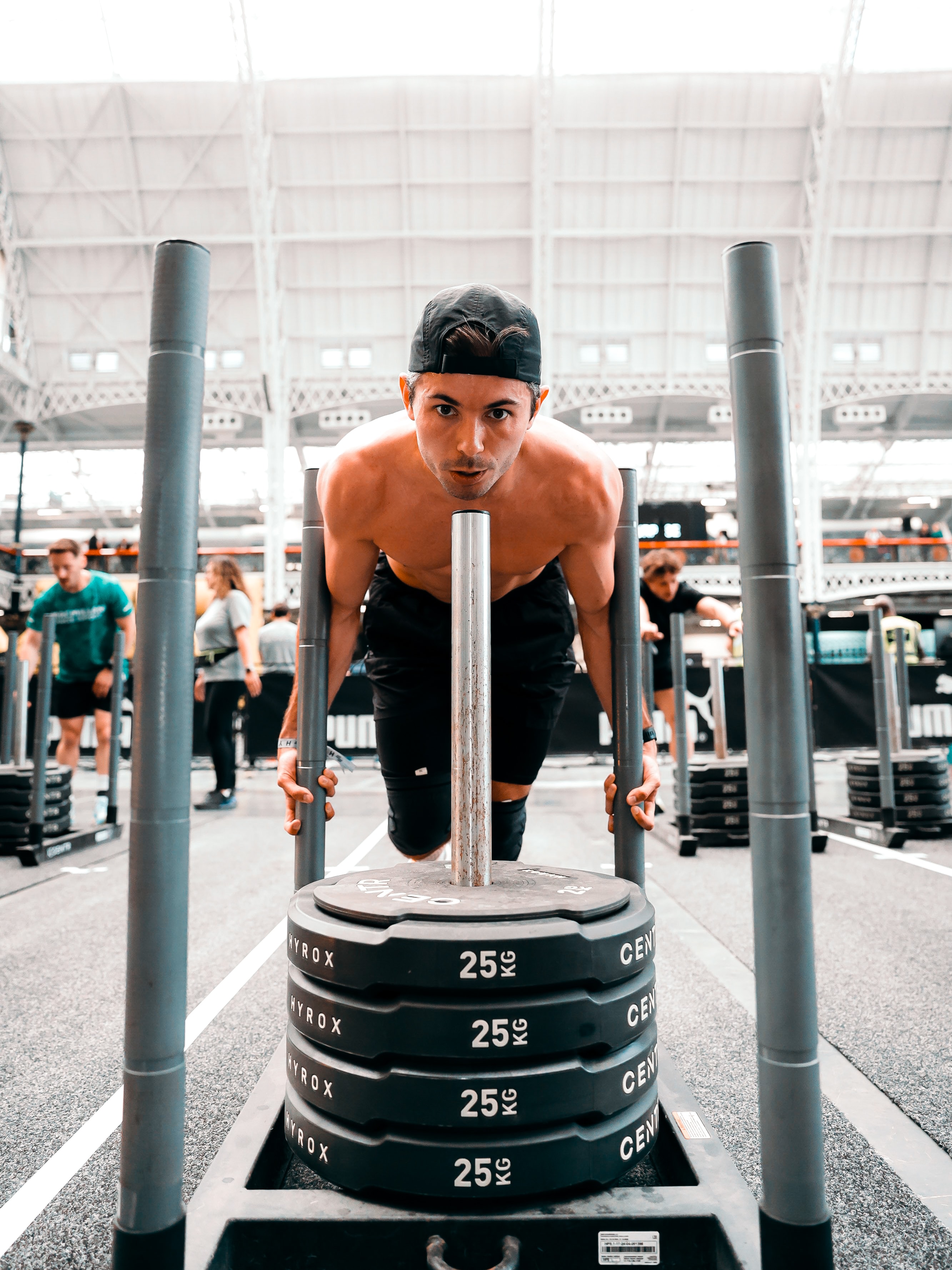 Sam pushing a weighted sled during a Hyrox event
