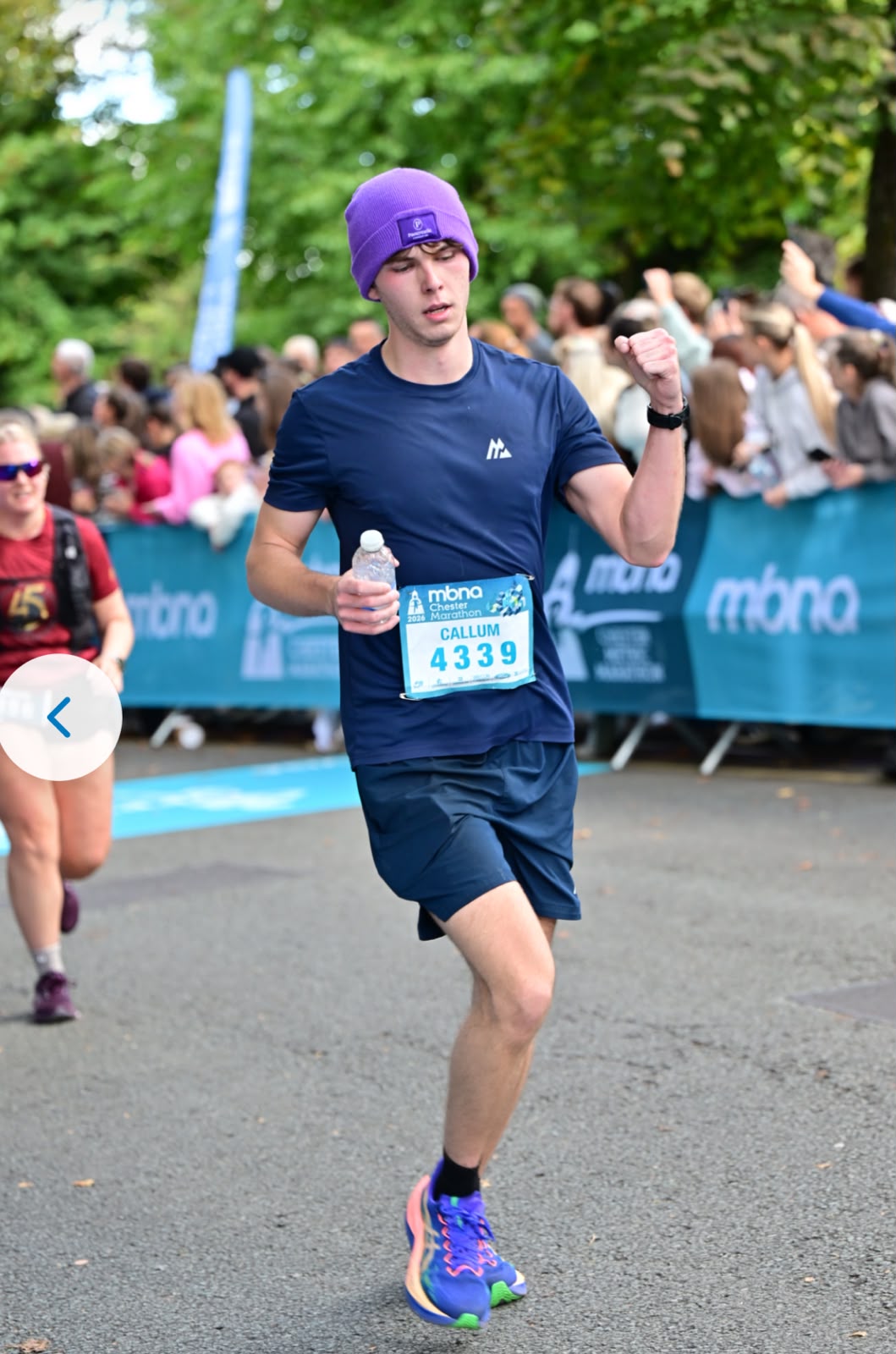 Callum running the Chester Marathon in his purple beanie, bib 4339, with his fist raised