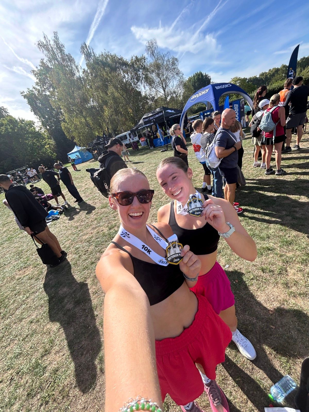 Tessa and a friend holding their medals after the Battersea Park 10K
